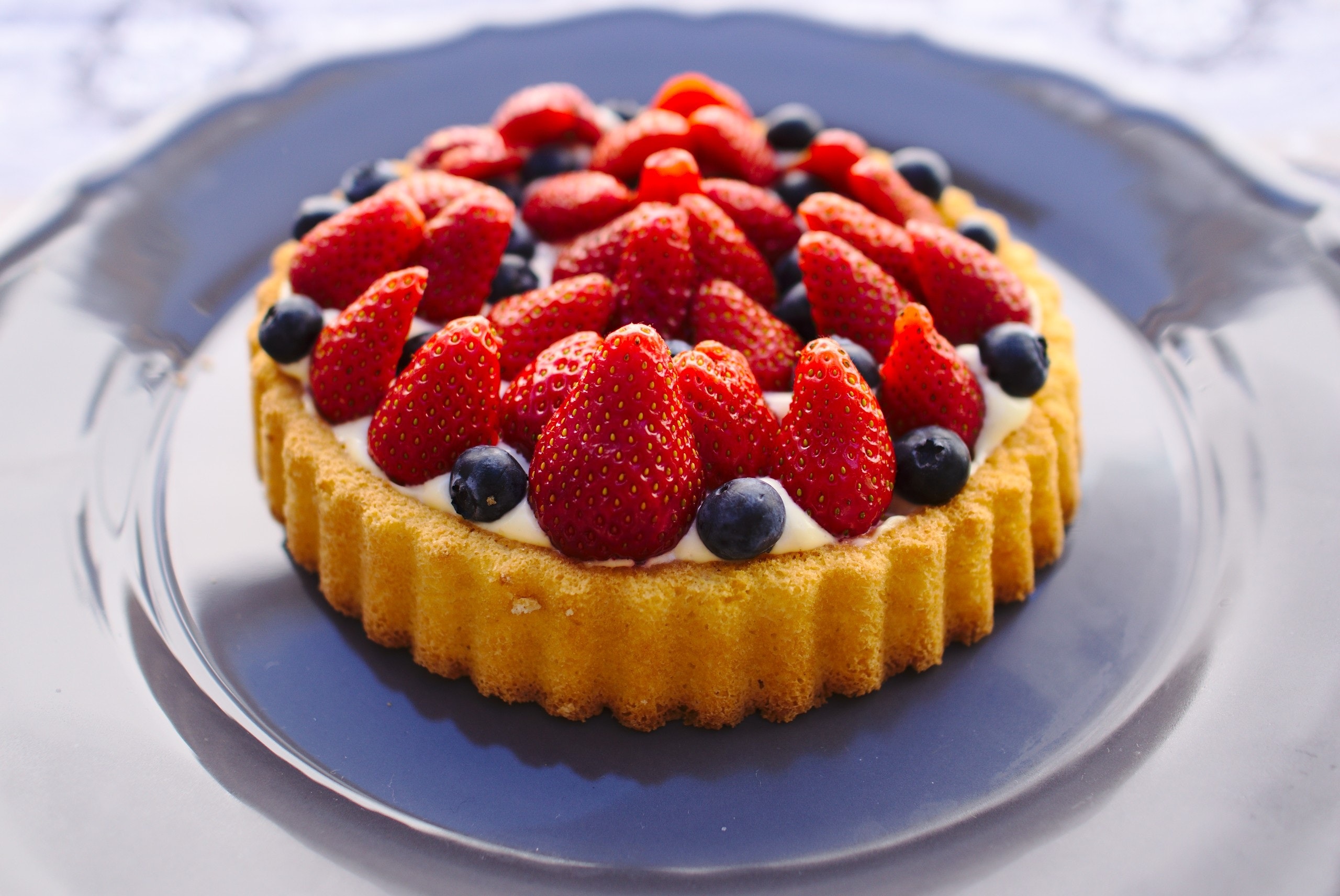 Cake topped with strawberries and blueberries